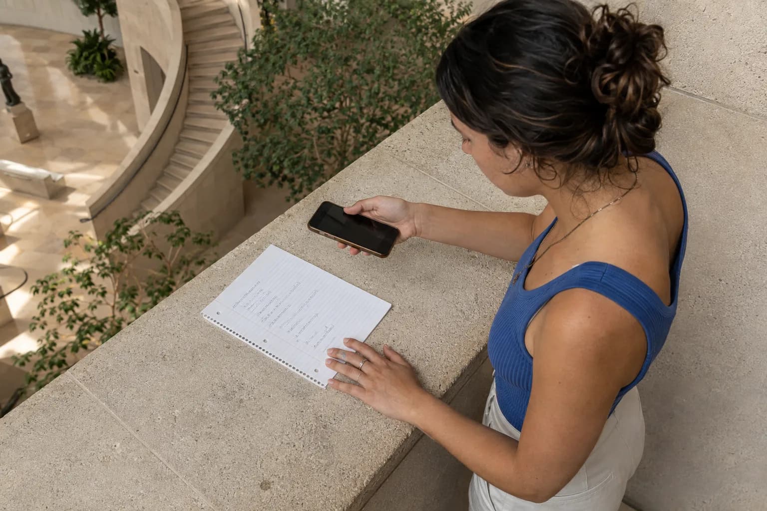 Studente adulto che fotografa un problema di matematica completo su una pagina piatta di un taccuino in un atrio luminoso