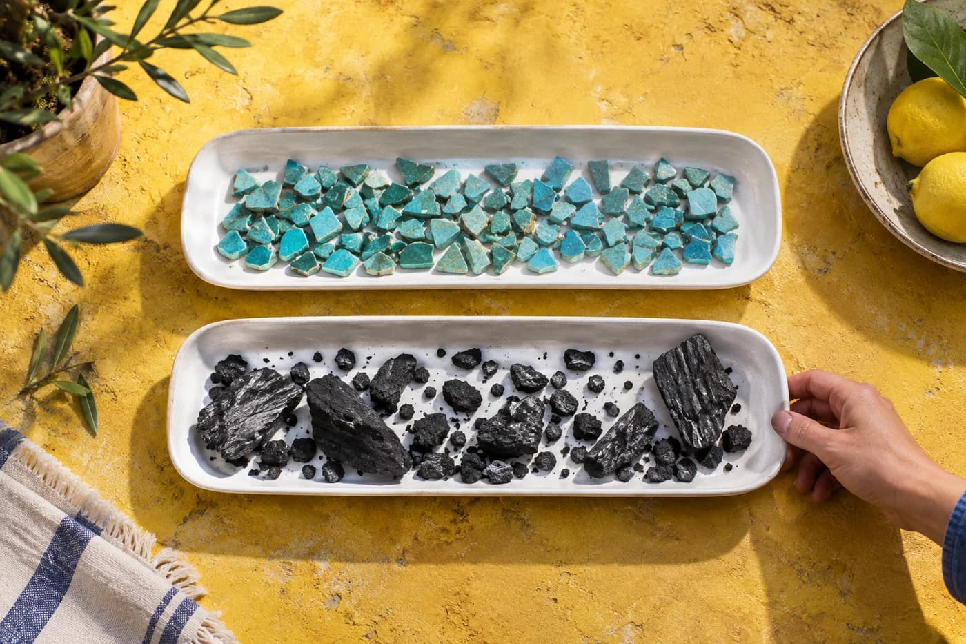 Two white trays comparing similarly sized turquoise fragments with a mixture of small and large charcoal pieces