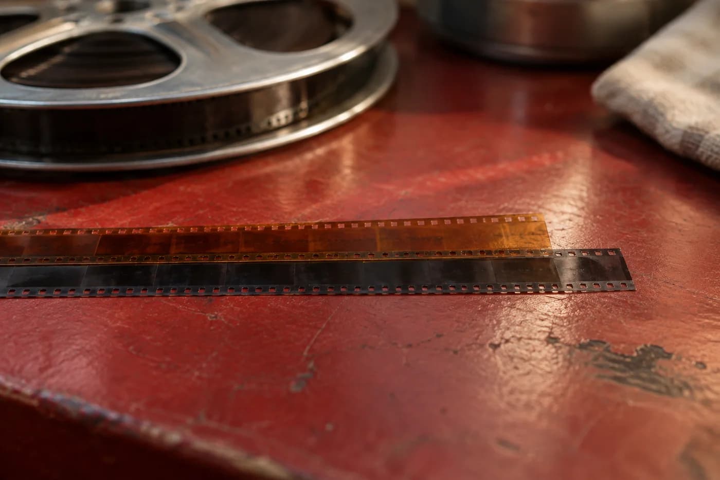 Nearly overlapping equal-width amber and smoke-gray strips leaving a short uncovered end on a scarlet archive table